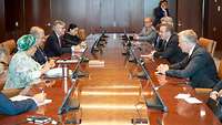 Pistorius, Guterres und weitere Personen sitzen sich an einem langen Tisch gegenüber
