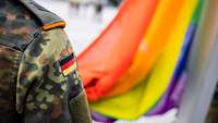 Eine Soldatin hält die Regenbogenflagge