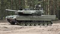 Eine Fotomontage eines Leopard 2 A8, dieser steht in einem Waldgebiet