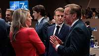 Mélanie Joly, Emmanuel Macron und Boris Pistorius stehen in einem Konferenzsaal im Gespräch.