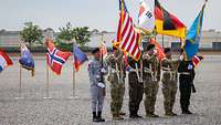 Soldaten stehen mit den Flaggen der USA, von Südkorea, Deutschland und der United#en Nations#en Command#en nebeneinander