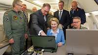 Von der Leyen und weitere Personen vor einem Laptop im Airbus A319CJ OH