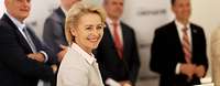 Von der Leyen am Podium, im Hintergrund Männer in Anzügen